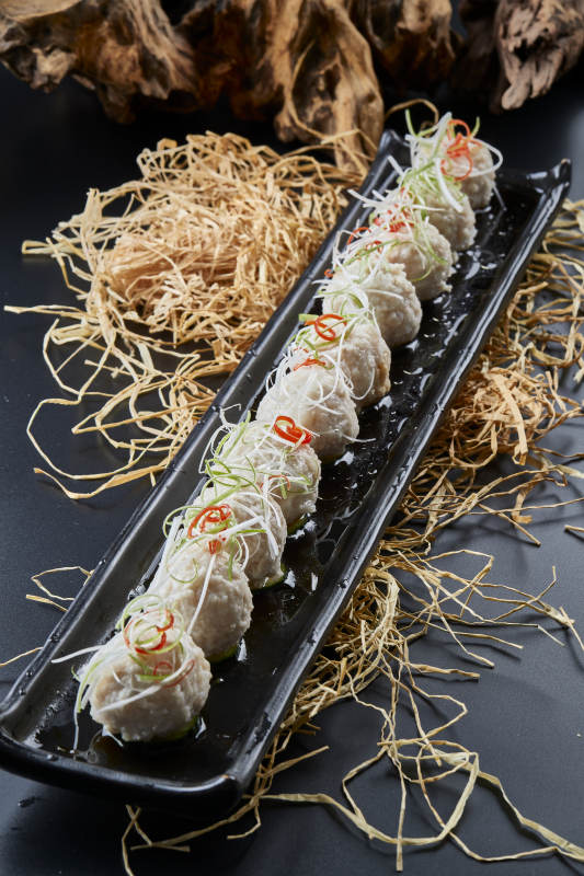 黑长瓷盘装的浇汁清汤萝卜丸子图片