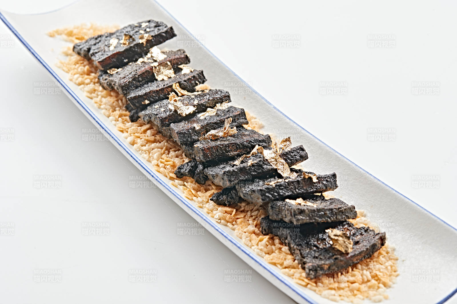 白色瓷盘装的墨鱼汁香煎猪五花肉图片