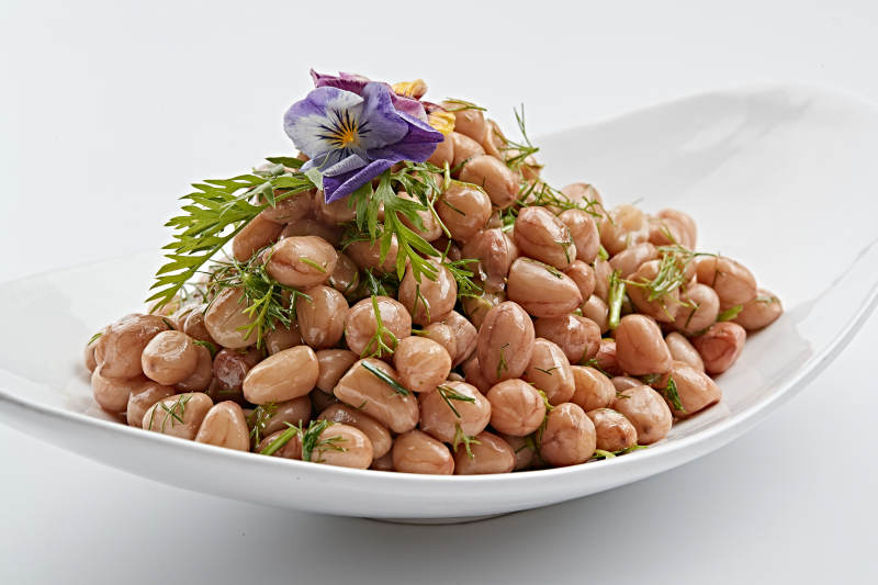 白色瓷盘装的茴香拌煮花生图片