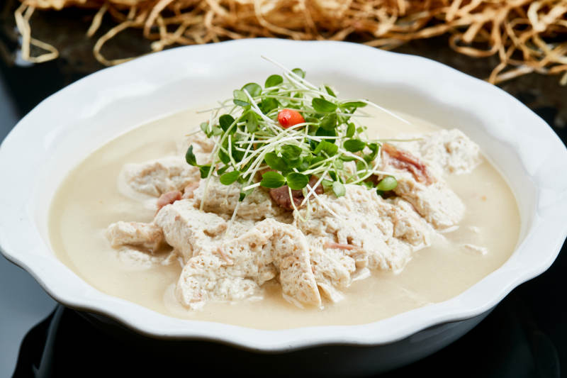 白色瓷餐具装的鲜鸡汤自制豆腐图片