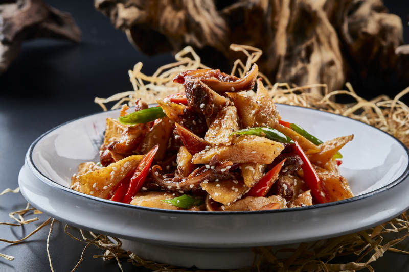 青瓷盘装的酱香红薯脆猪耳图片