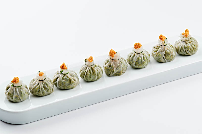 白色瓷餐具装的蟹籽糯米冰皮烧麦图片