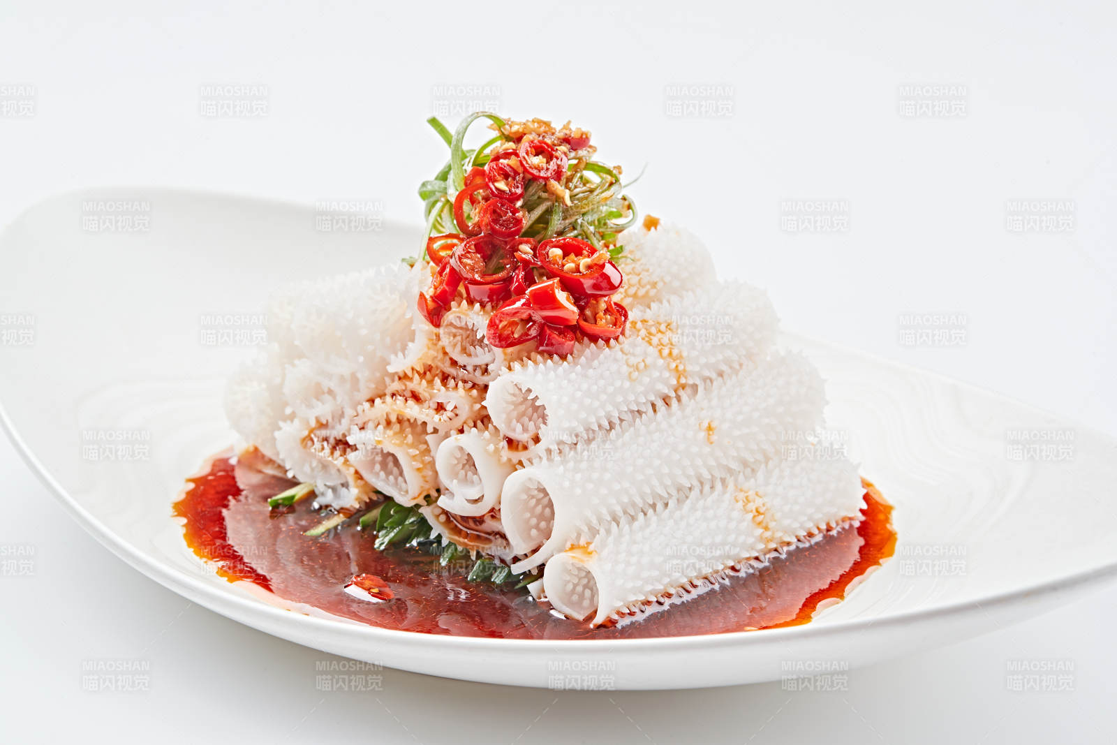 白色瓷盘装的红油墨鱼卷图片