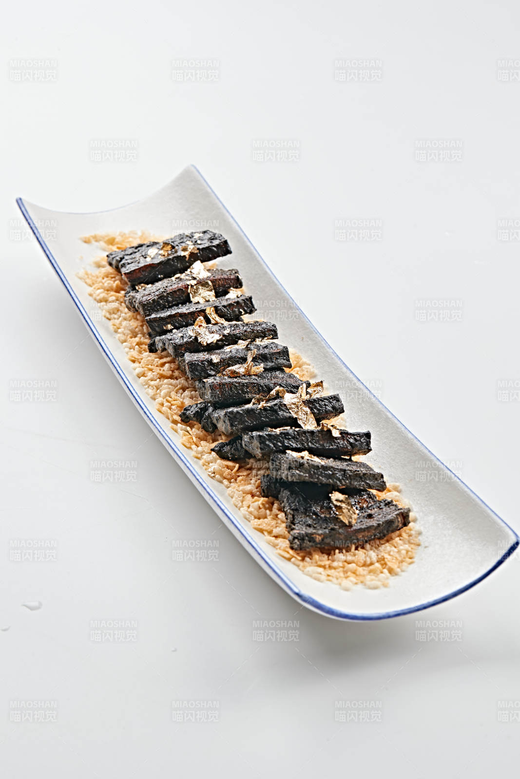 白色瓷盘装的墨鱼汁香煎猪五花肉图片