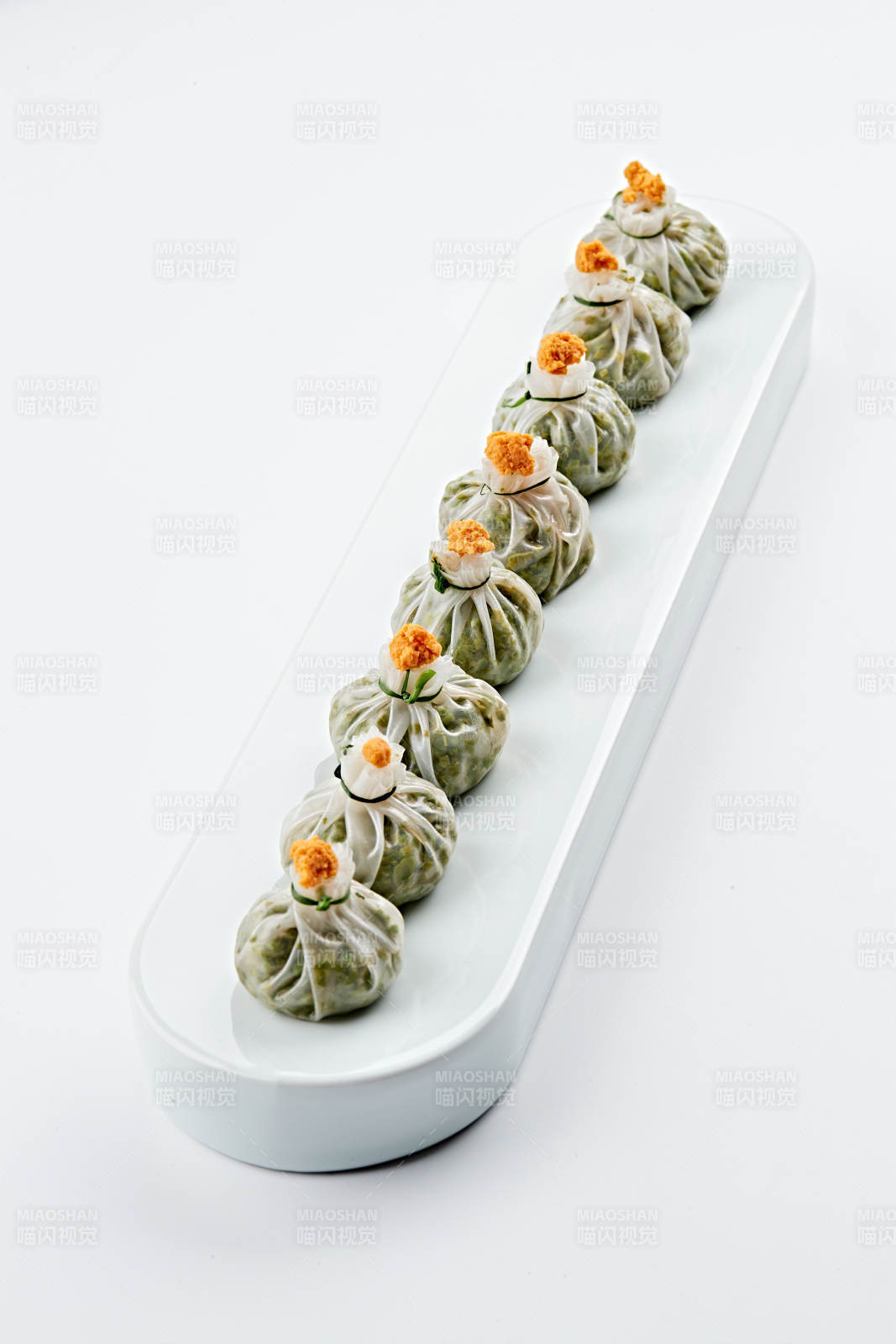 白色瓷餐具装的蟹籽糯米冰皮烧麦图片