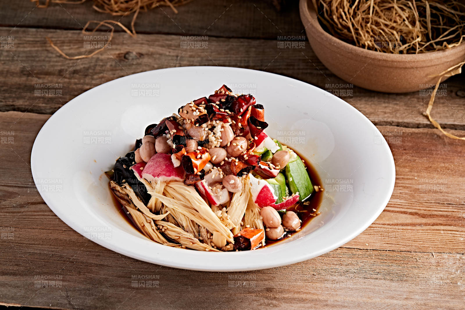 白色瓷盘装的捞汁果仁木耳黄瓜拌腐竹图片
