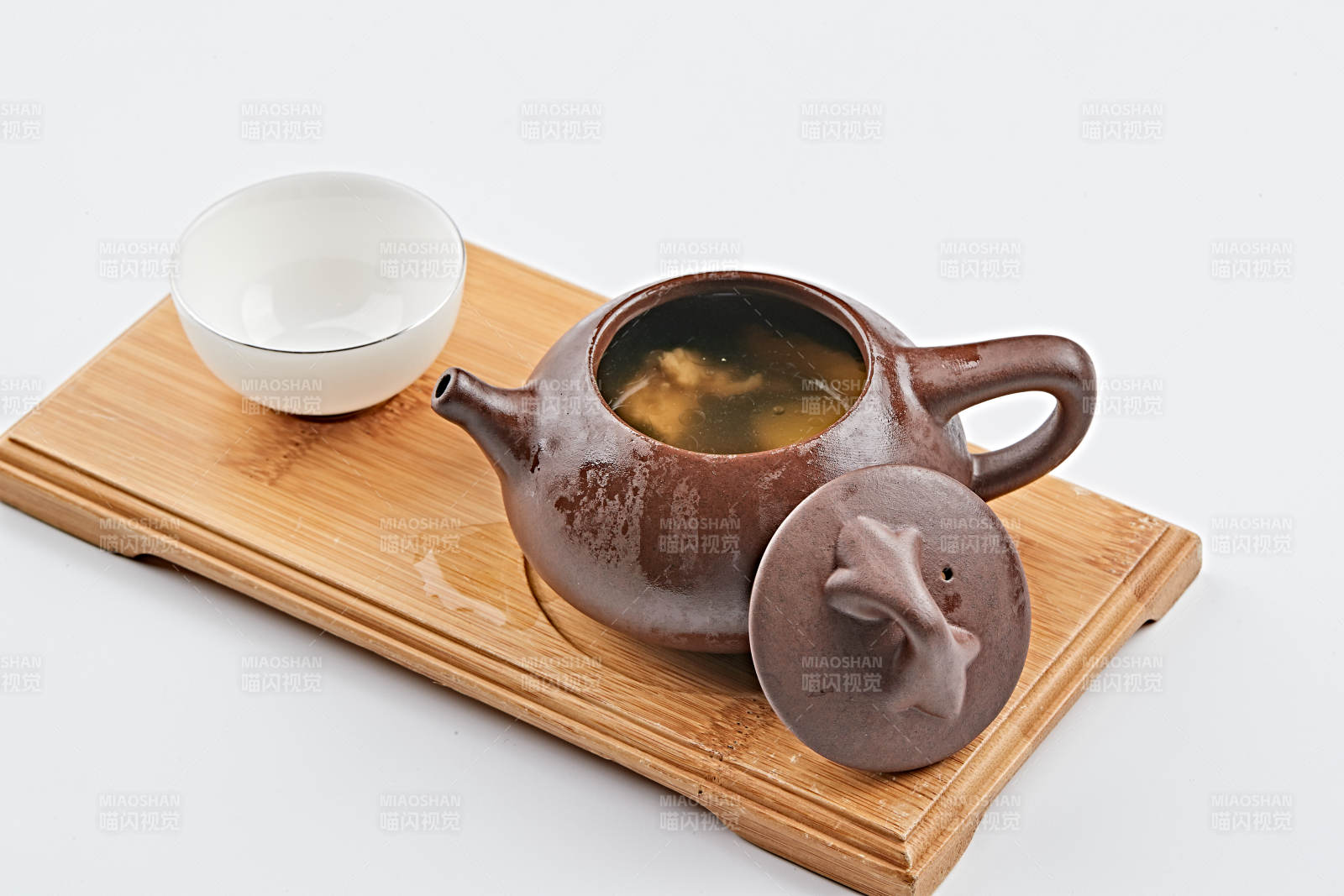 白色背景上摆放的紫砂当归土鸡汤图片