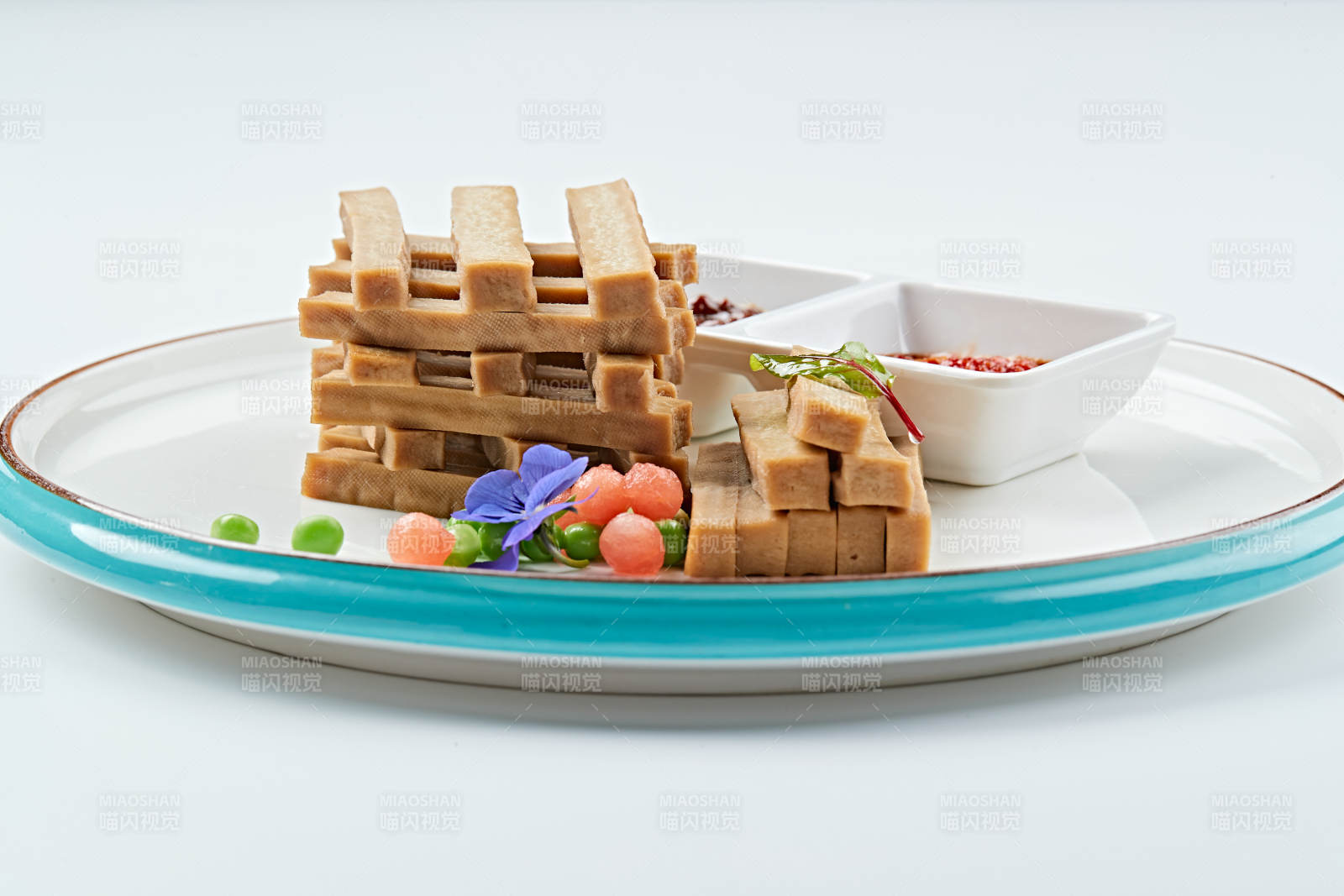 白色瓷盘装的蘸酱烟熏豆干图片