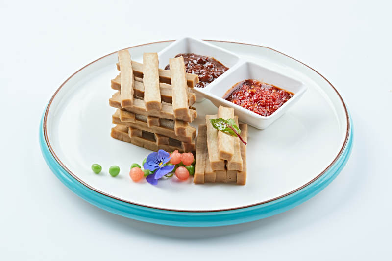 白色瓷盘装的蘸酱烟熏豆干图片