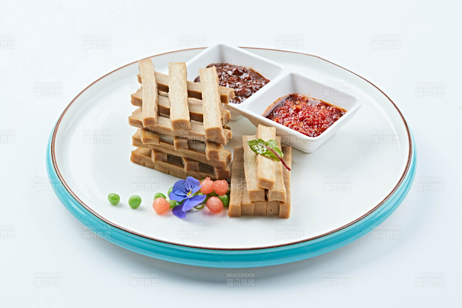 白色瓷盘装的蘸酱烟熏豆干图片