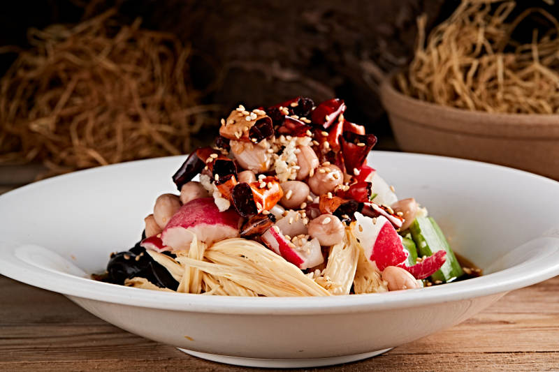 白色瓷盘装的捞汁果仁木耳黄瓜拌腐竹图片