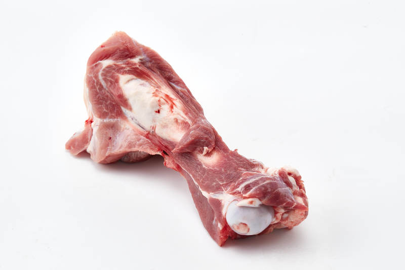 白色背景下的生鲜猪棒骨图片