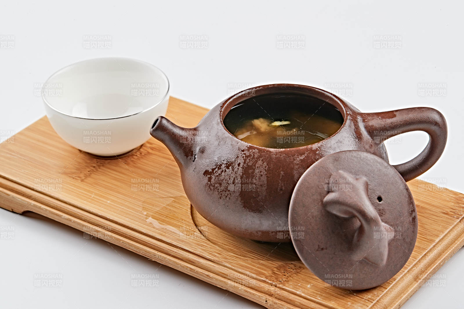 白色背景上摆放的紫砂当归土鸡汤图片