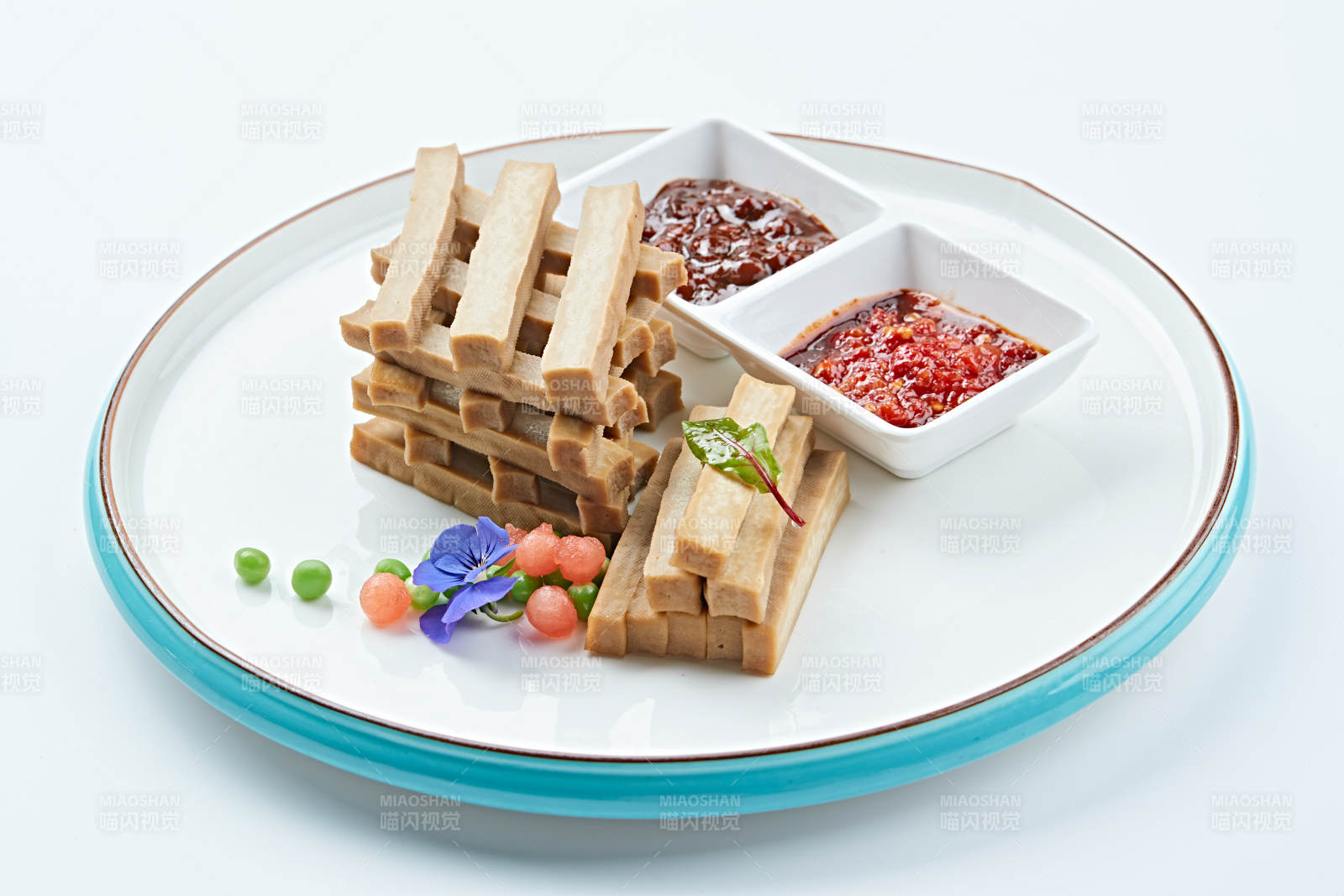 白色瓷盘装的蘸酱烟熏豆干图片