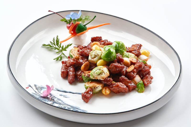 白色瓷盘装的酱爆银杏小甘蓝黑胡椒牛仔粒图片