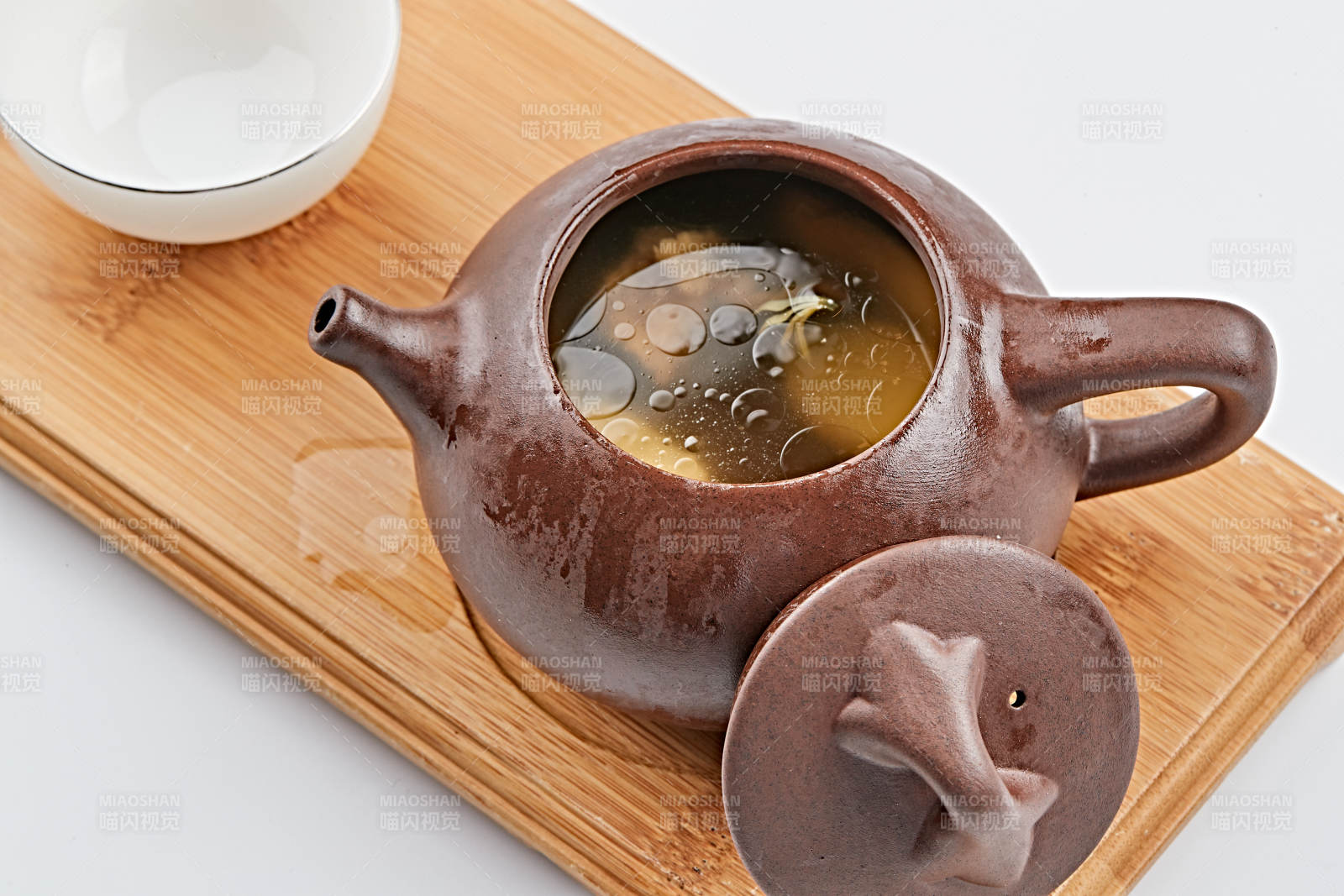 白色背景上摆放的紫砂当归土鸡汤图片