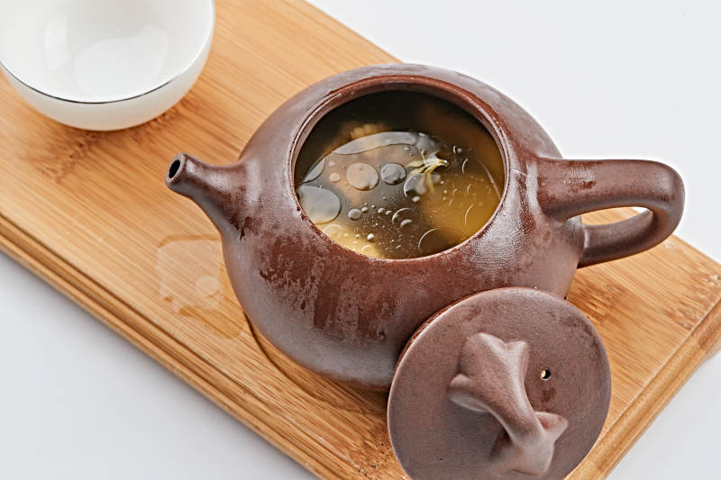 白色背景上摆放的紫砂当归土鸡汤图片