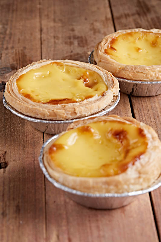 木板上的香烤葡式蛋挞图片