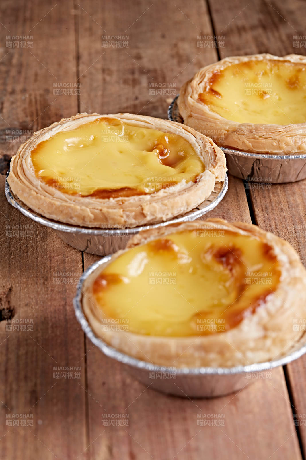 木板上的香烤葡式蛋挞图片
