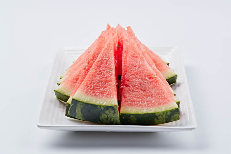 白色瓷盘装的切好的西瓜图片
