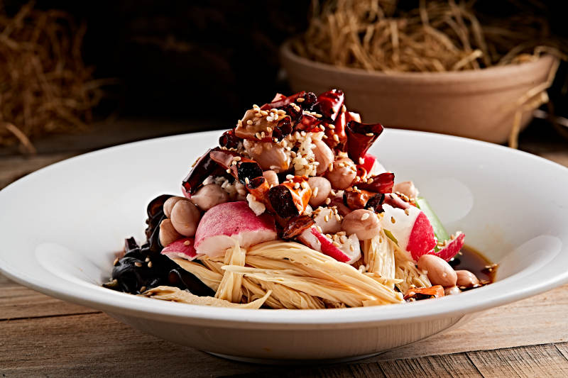 白色瓷盘装的捞汁果仁木耳黄瓜拌腐竹图片