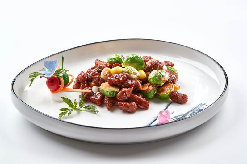 白色瓷盘装的酱爆银杏小甘蓝黑胡椒牛仔粒图片