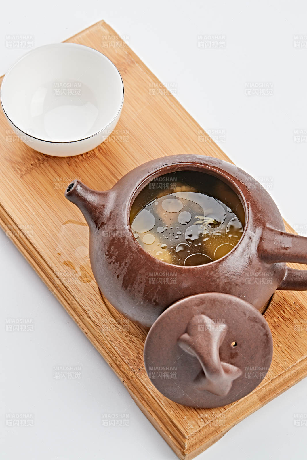 白色背景上摆放的紫砂当归土鸡汤图片