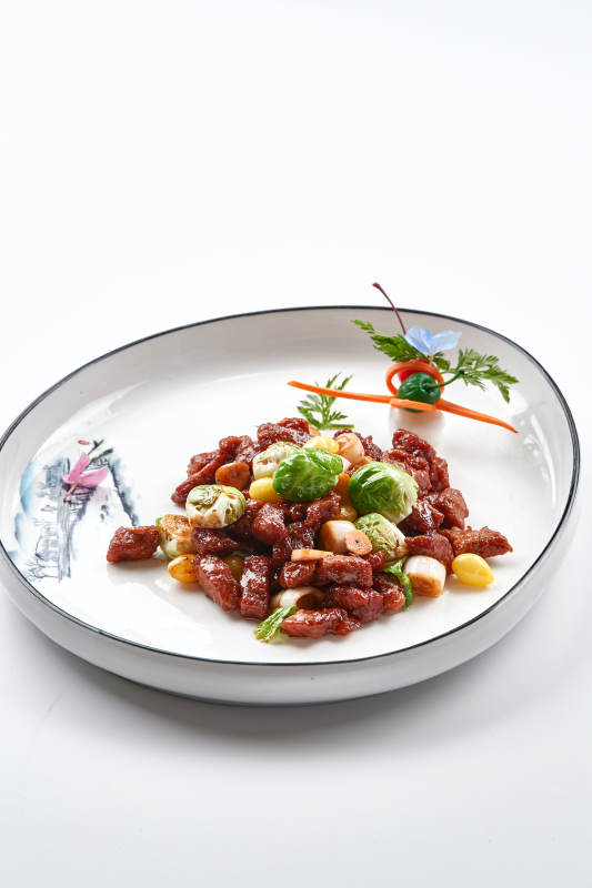 白色瓷盘装的酱爆银杏小甘蓝黑胡椒牛仔粒图片