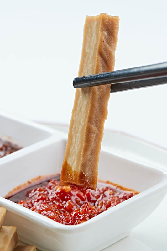 白色瓷盘装的蘸酱烟熏豆干图片