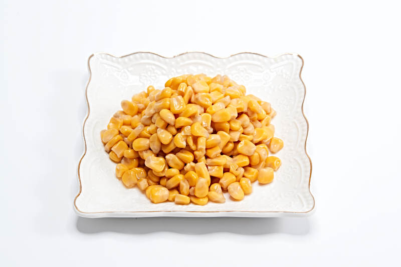 白色背景上的甜玉米粒图片