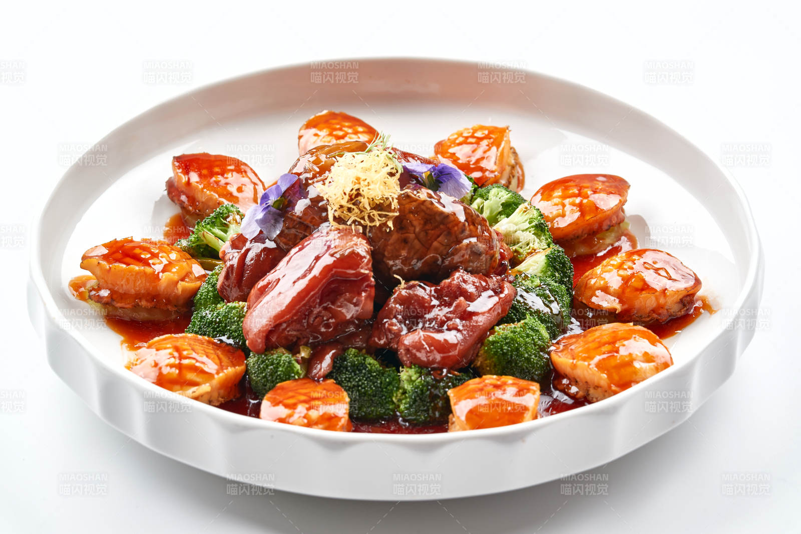 白色瓷盘装的酱烧猪肘鲜鲍鱼图片