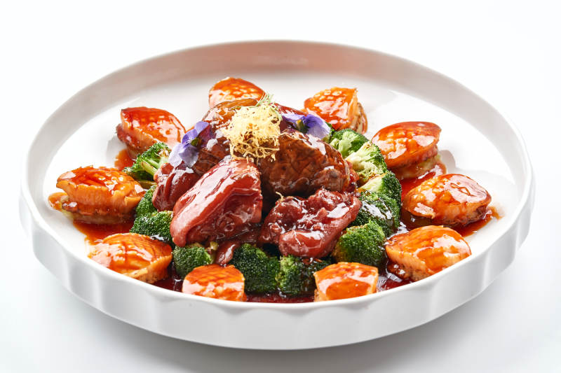 白色瓷盘装的酱烧猪肘鲜鲍鱼图片