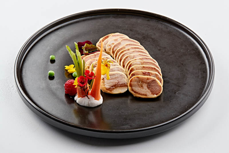 黑色瓷盘装的豆皮压肘花图片