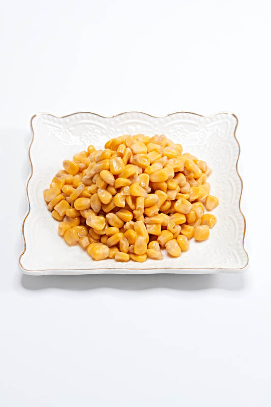 白色背景上的甜玉米粒图片