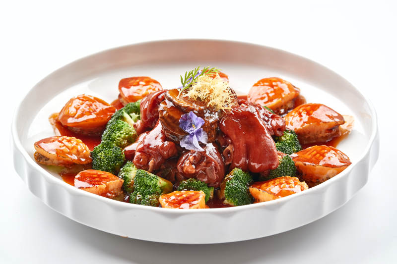 白色瓷盘装的酱烧猪肘鲜鲍鱼图片