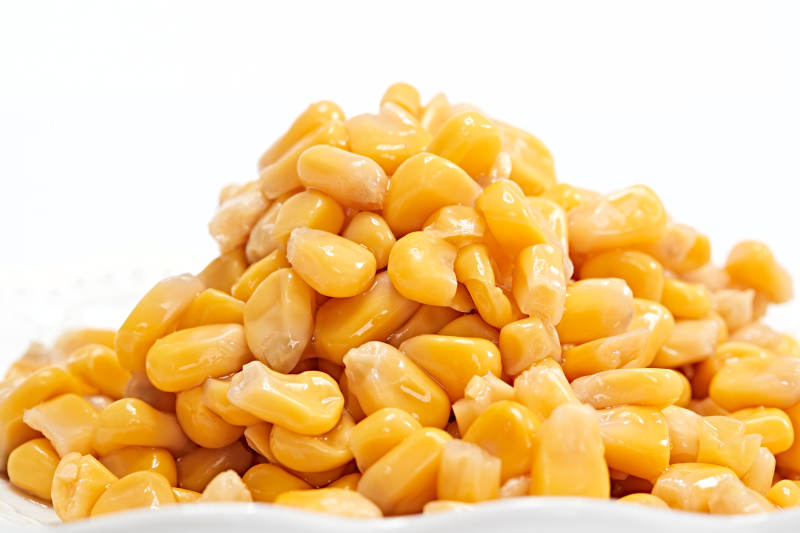 白色背景上的甜玉米粒图片