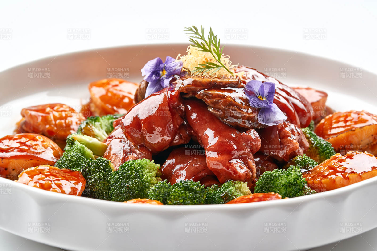 白色瓷盘装的酱烧猪肘鲜鲍鱼图片