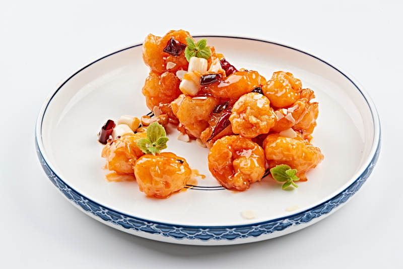 白色青花瓷盘装的川味宫保大虾球图片