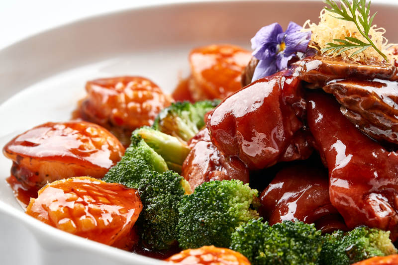 白色瓷盘装的酱烧猪肘鲜鲍鱼图片