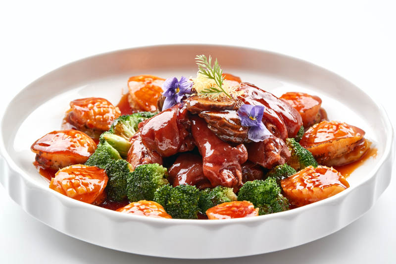 白色瓷盘装的酱烧猪肘鲜鲍鱼图片