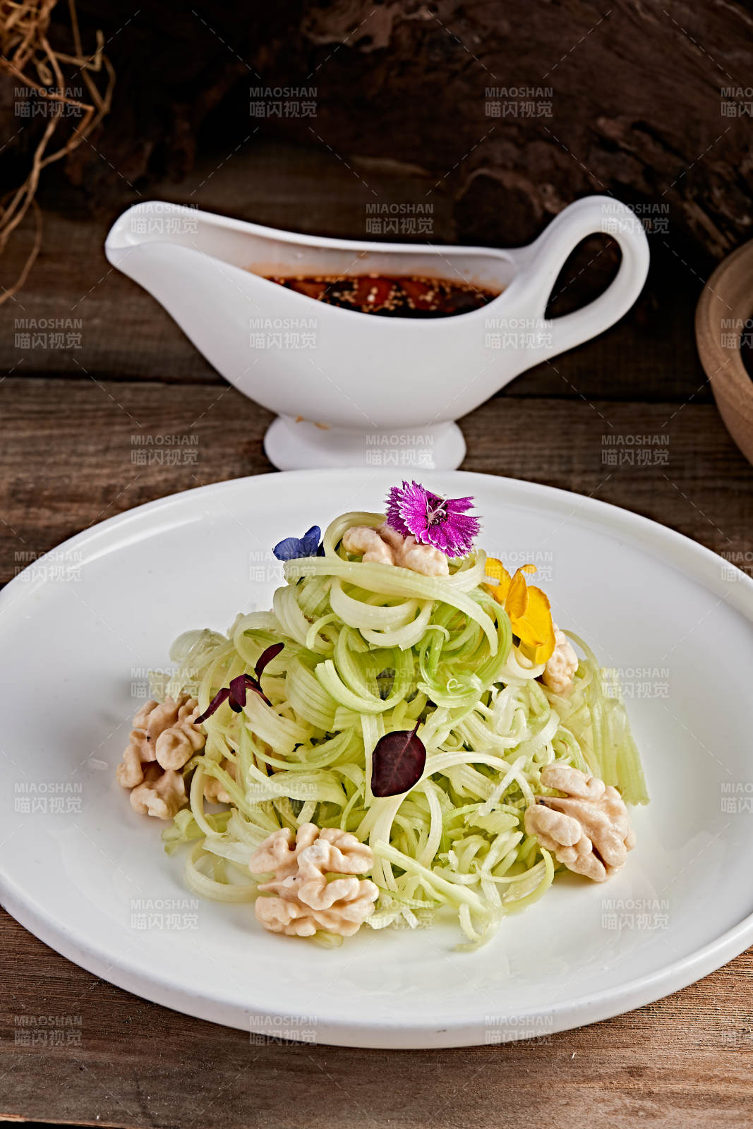 白色瓷盘装的浇汁桃仁西芹丝图片