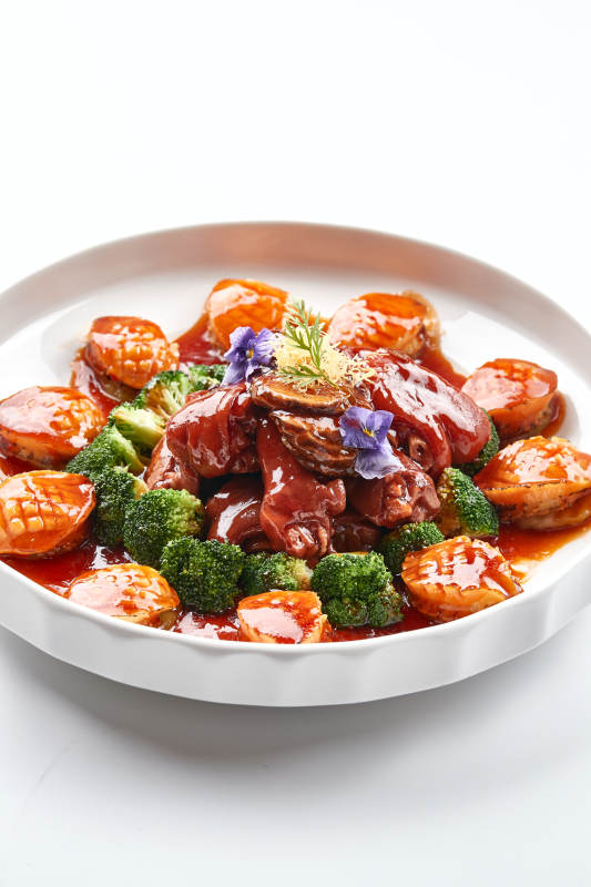 白色瓷盘装的酱烧猪肘鲜鲍鱼图片