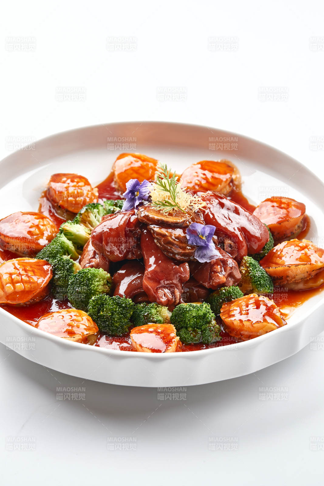 白色瓷盘装的酱烧猪肘鲜鲍鱼图片
