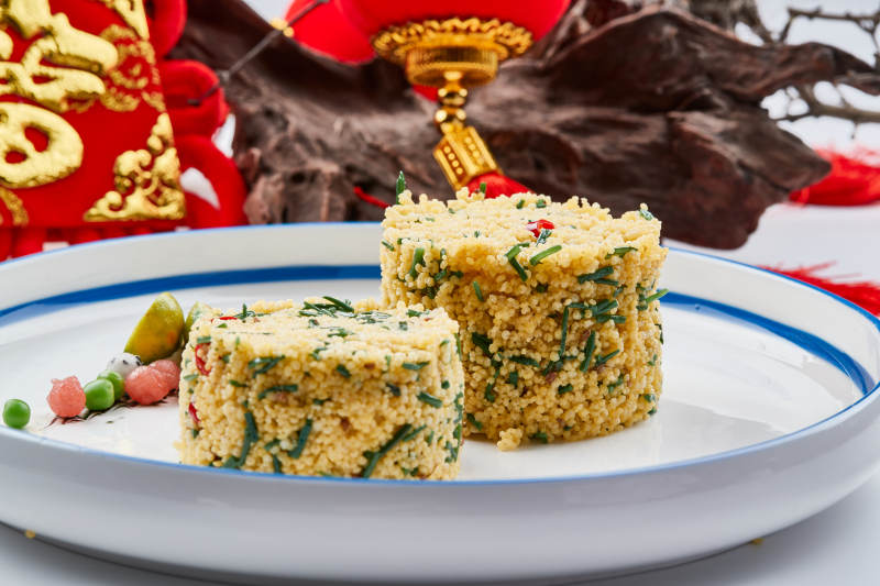 白色瓷盘装的的韭菜小米糕图片