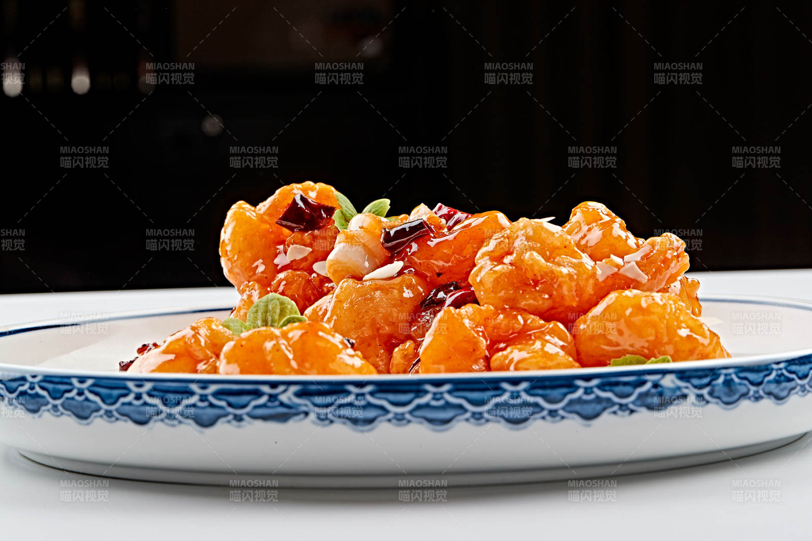 白色青花瓷盘装的川味宫保大虾球图片