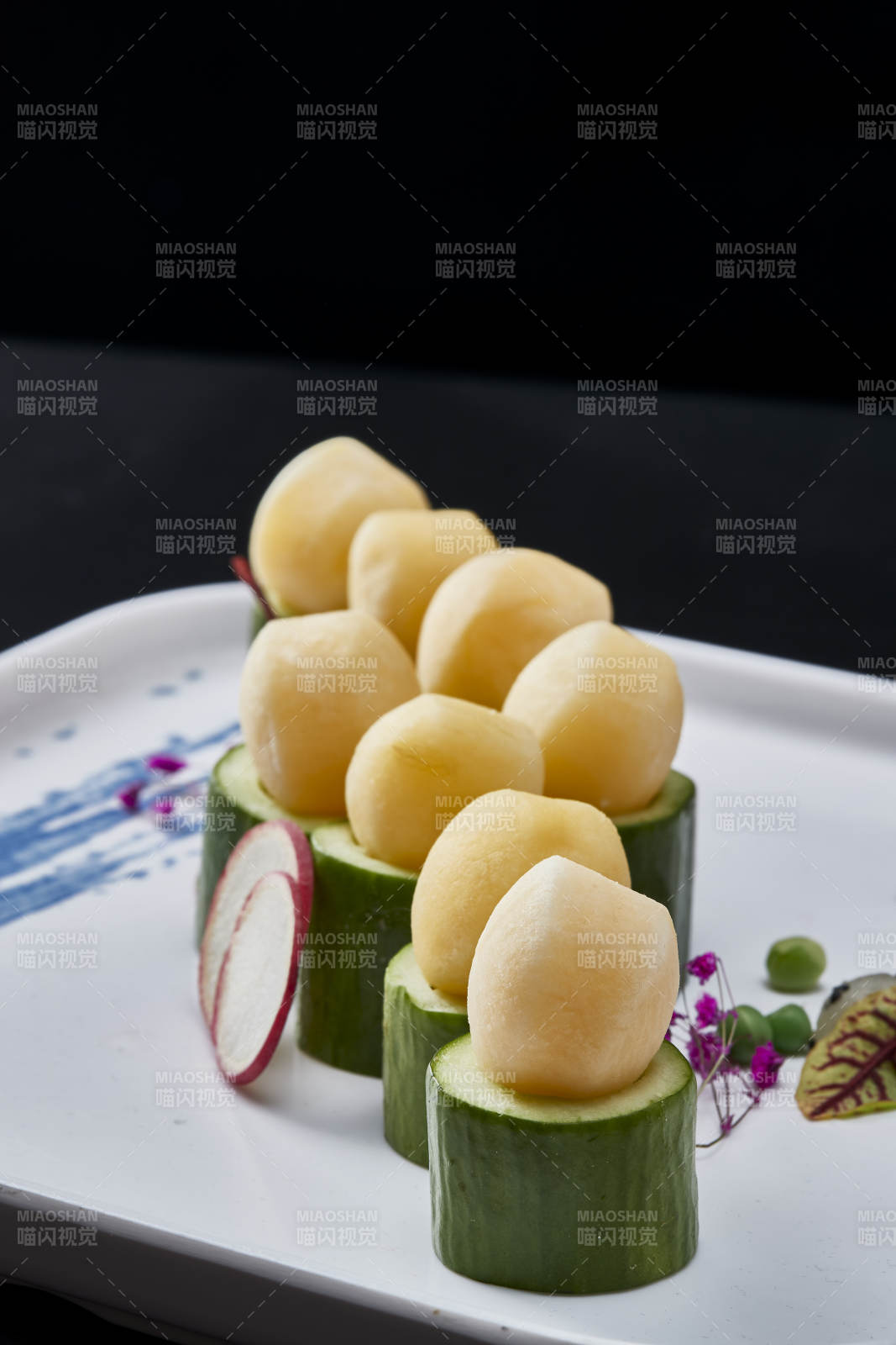 黑色背景上的创意美食手打马铃薯球配乳瓜段图片