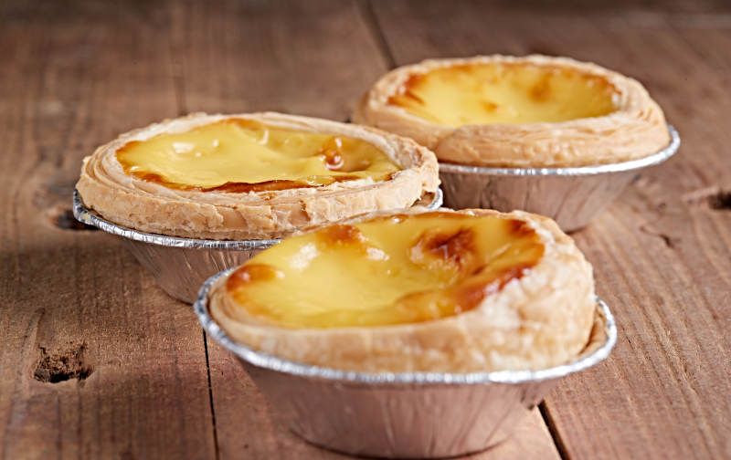 木板上的香烤葡式蛋挞图片