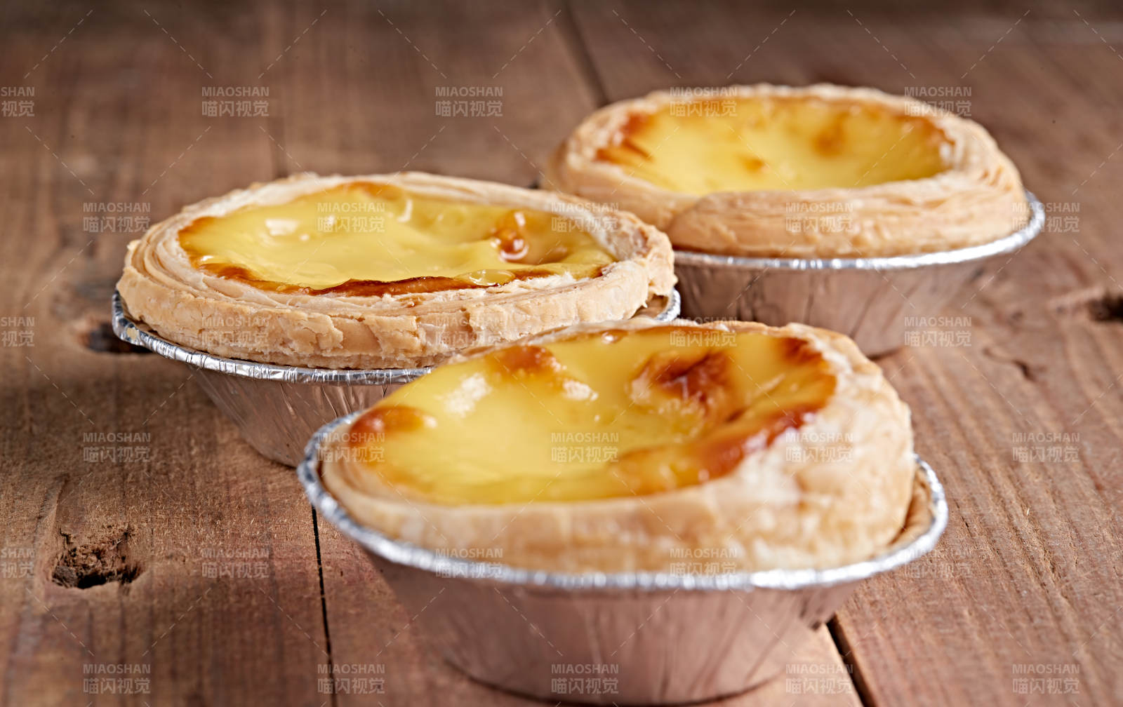 木板上的香烤葡式蛋挞图片