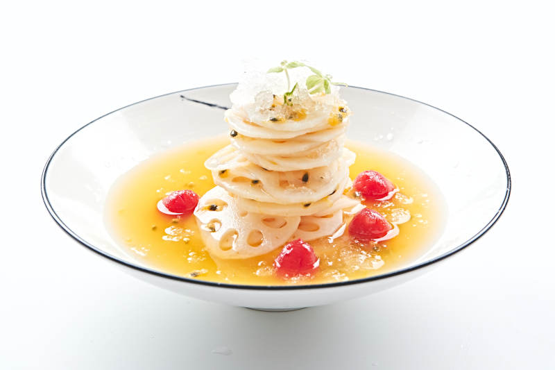 白色瓷盘装的橙汁冰镇莲藕片图片