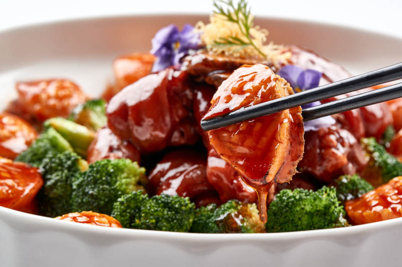 白色瓷盘装的酱烧猪肘鲜鲍鱼图片